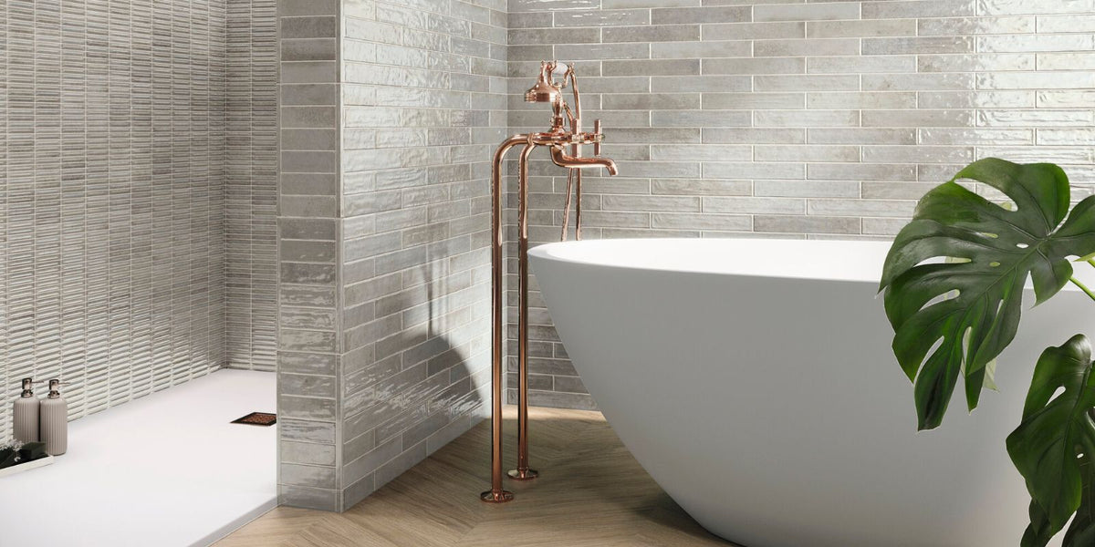Sleek contemporary bathroom with white freestanding tub and light beige subway wall tiles.