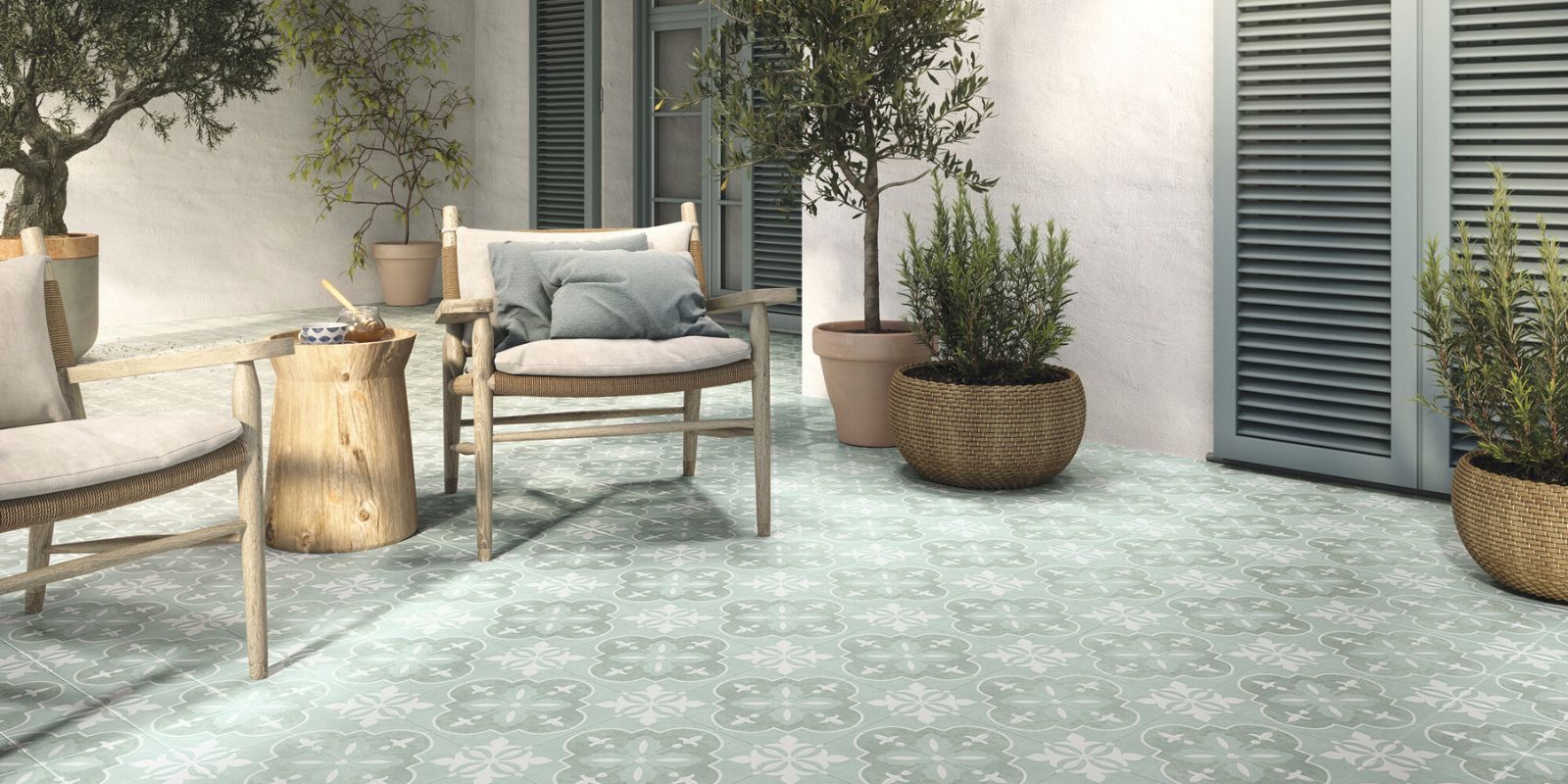 Mediterranean inspired outdoor seating area with pale green patterned mosaic floor tiles.