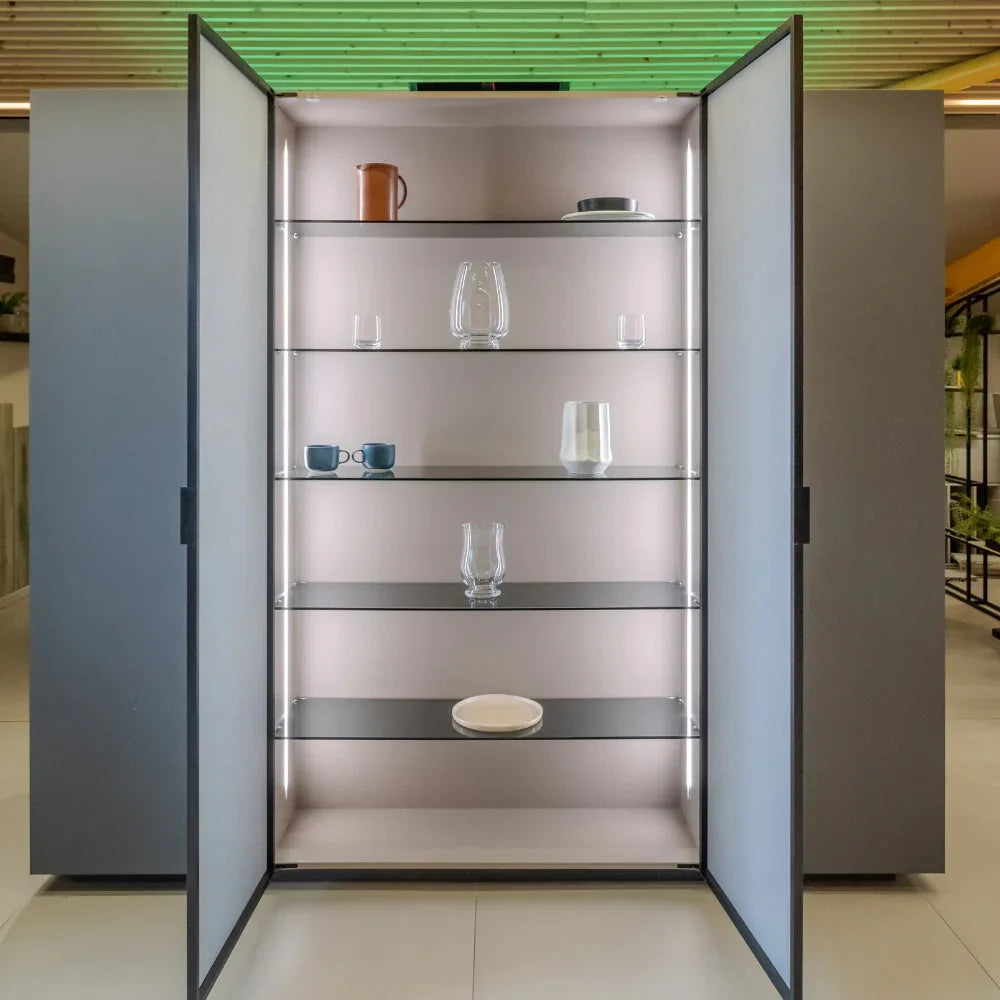 Modern glass display cabinet with open doors showing shelves and decorative items.