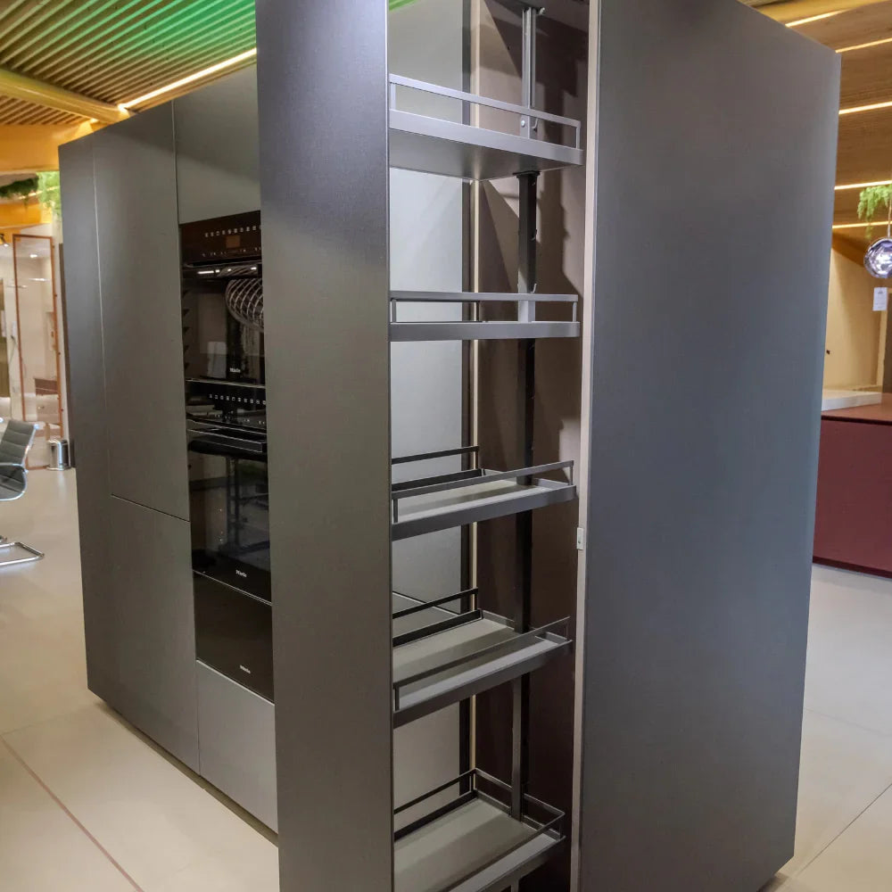 Modern kitchen cabinet with pull-out shelves in a showroom setting
