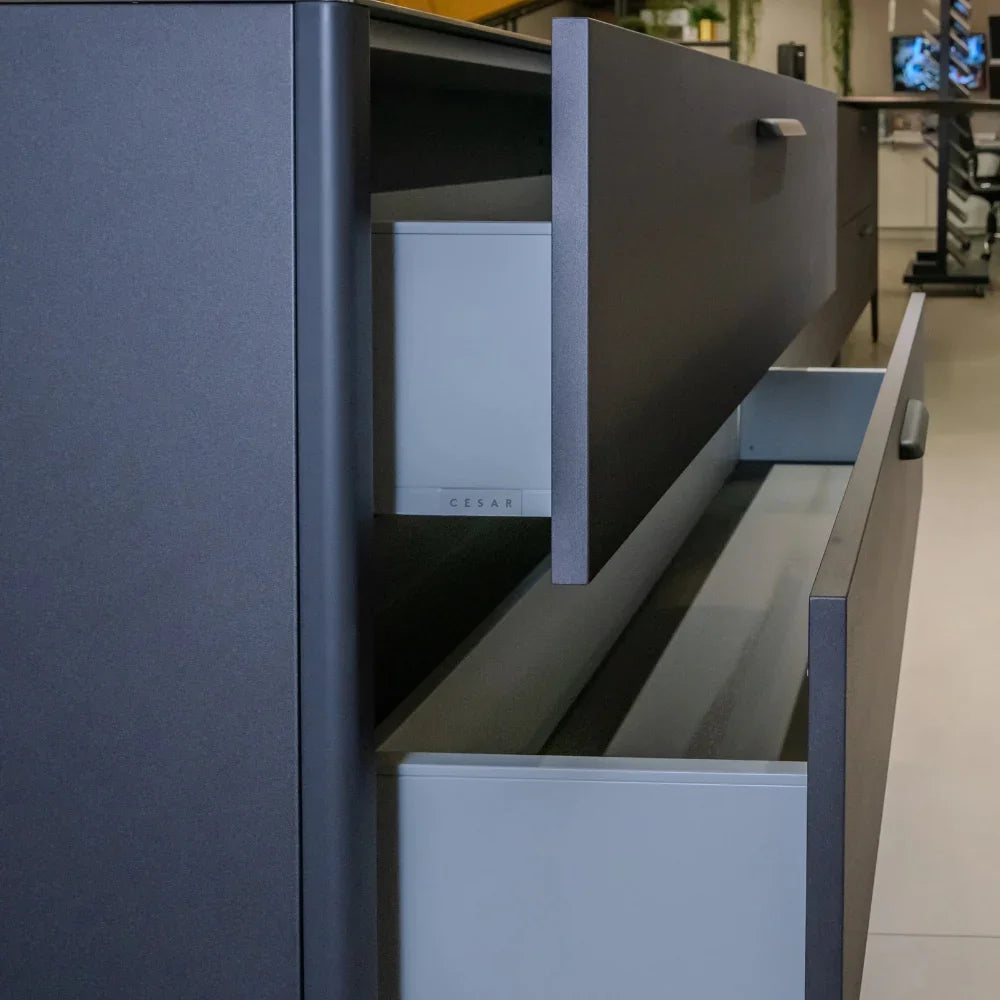 Grey kitchen cabinet with open drawers in a modern kitchen setting