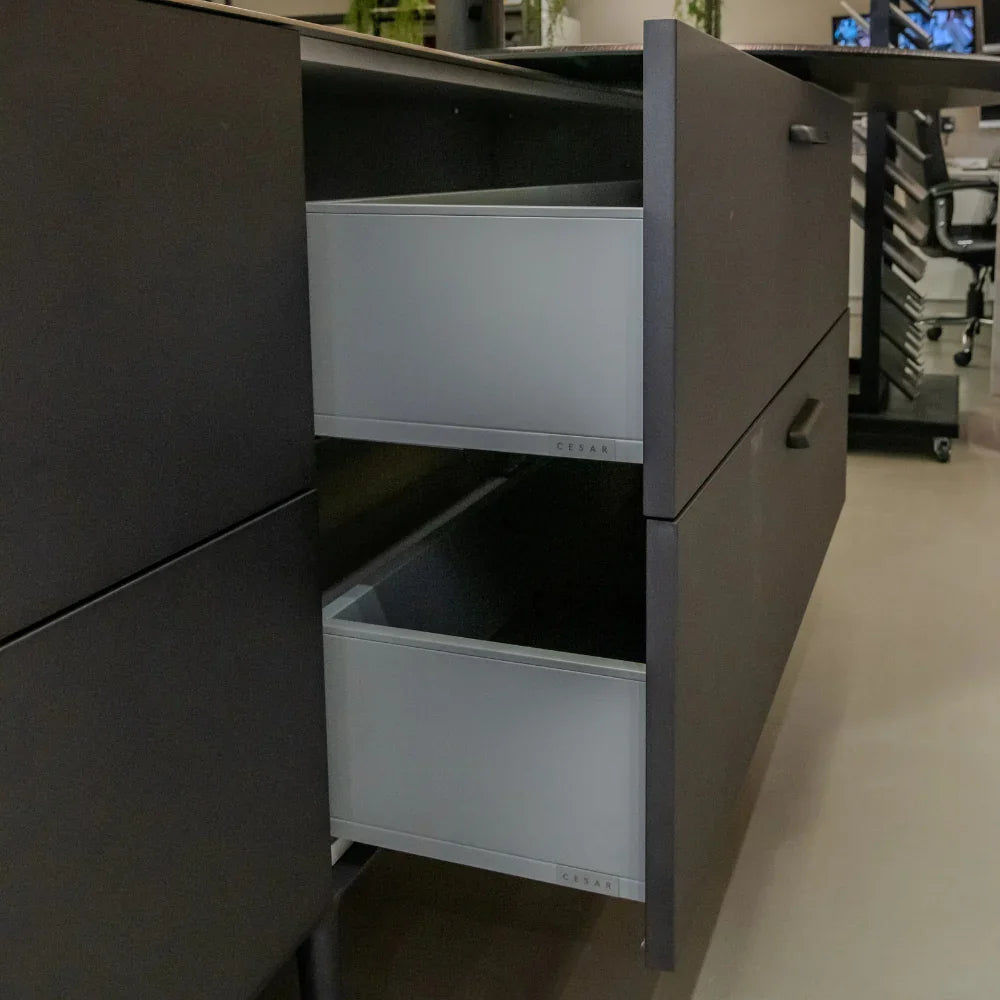 Dark grey kitchen cabinet with open drawers in a kitchen setting