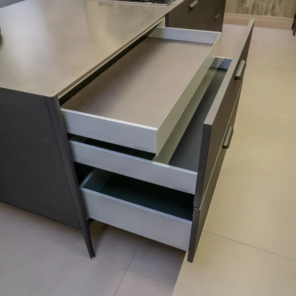 Grey kitchen cabinet with open drawers in a modern kitchen setting
