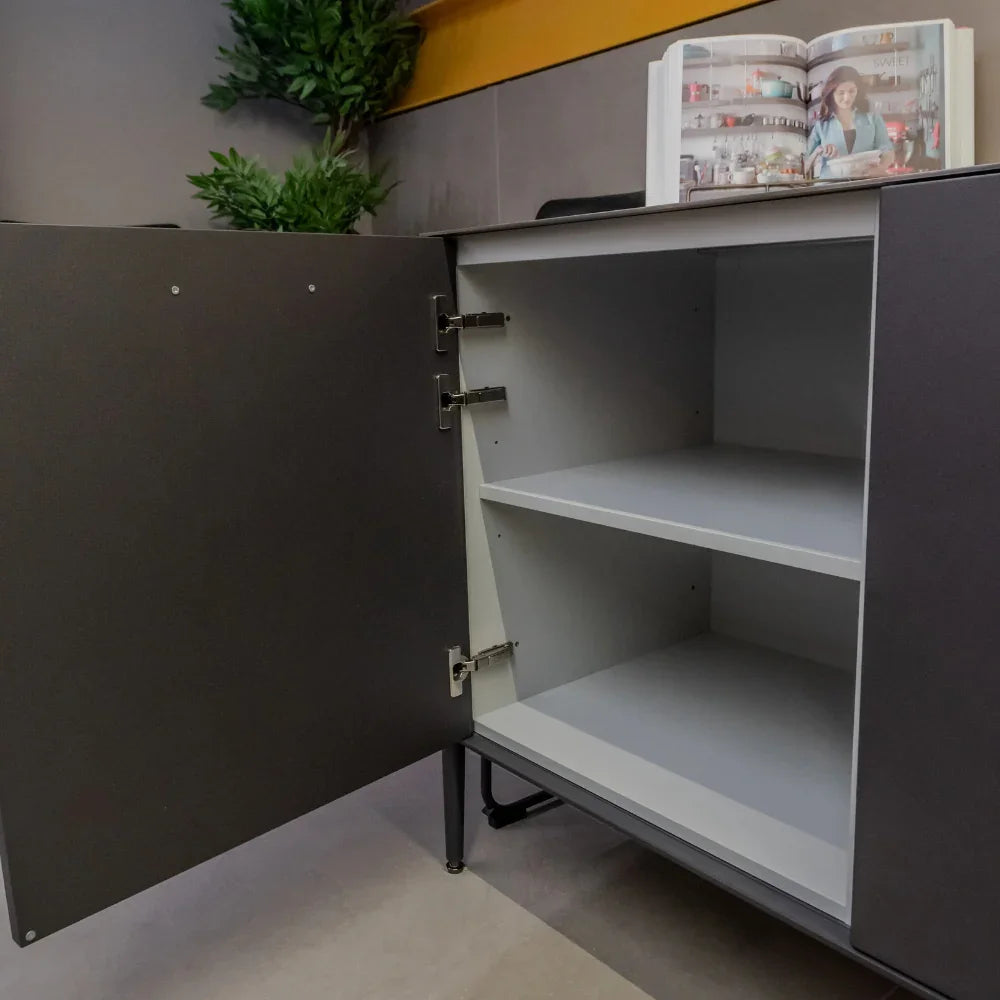 Grey cabinet with an open door, shelves, and a magazine on top.