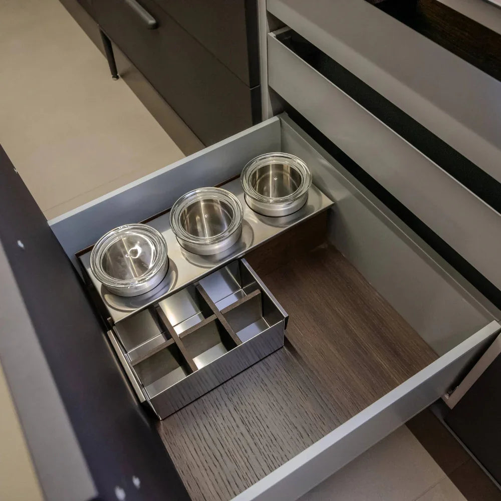 Open drawer with metal containers and organisational components