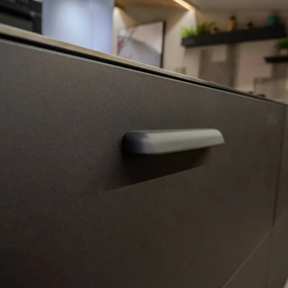 Close-up of a kitchen cabinet handle with a blurred background