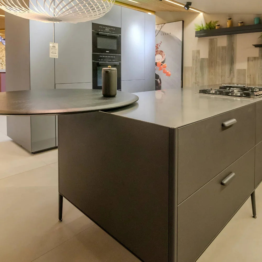 Modern kitchen with grey island and cabinets, featuring a stove and oven.