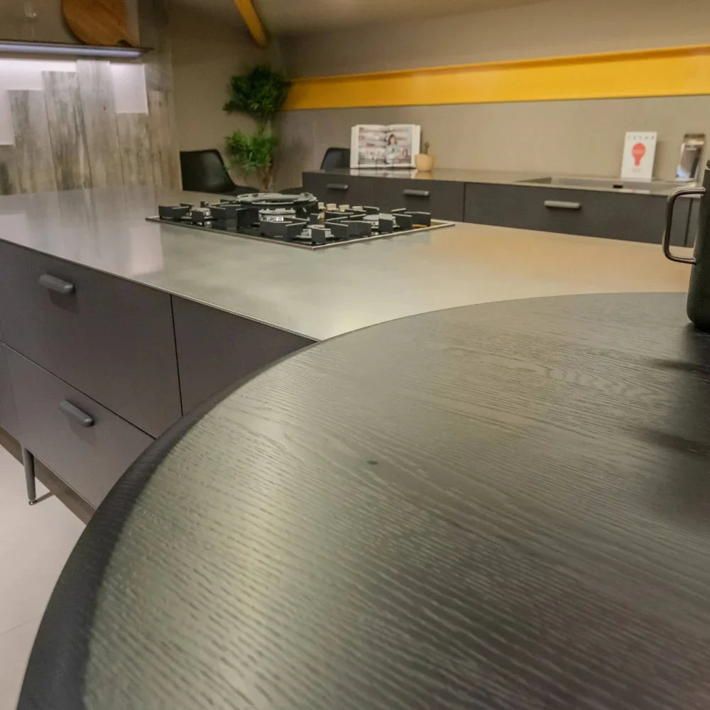 Modern kitchen with a round wooden table in the foreground