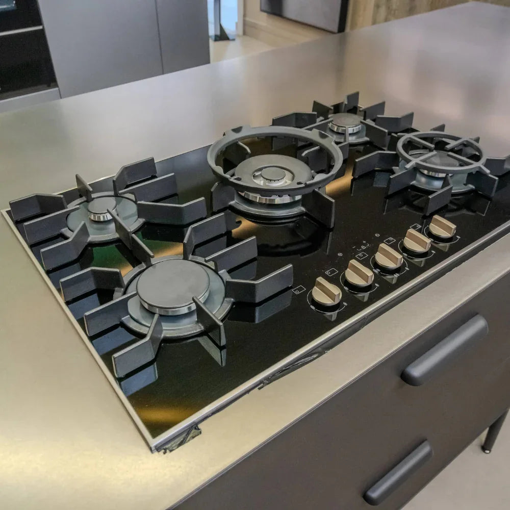 Modern gas stove on a kitchen counter with a neutral background