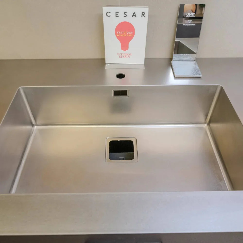 Stainless steel sink with a CESAR sign in the background