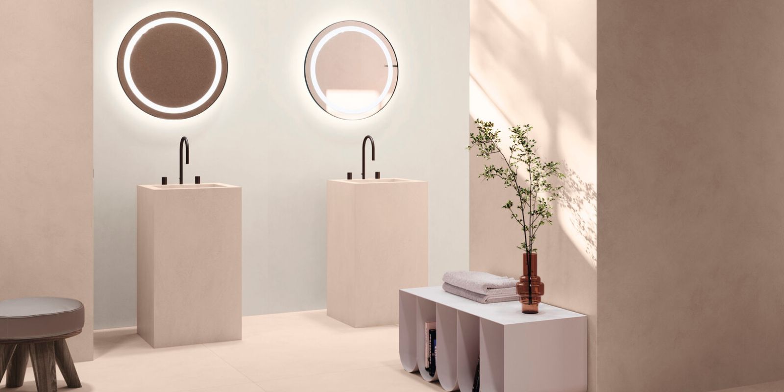 Pale pink toned bathroom, two sinks with two oval mirrors. 