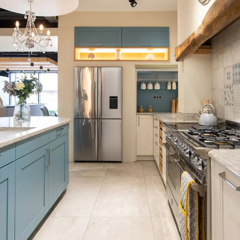Modern kitchen with stainless steel appliances and light blue cabinets.