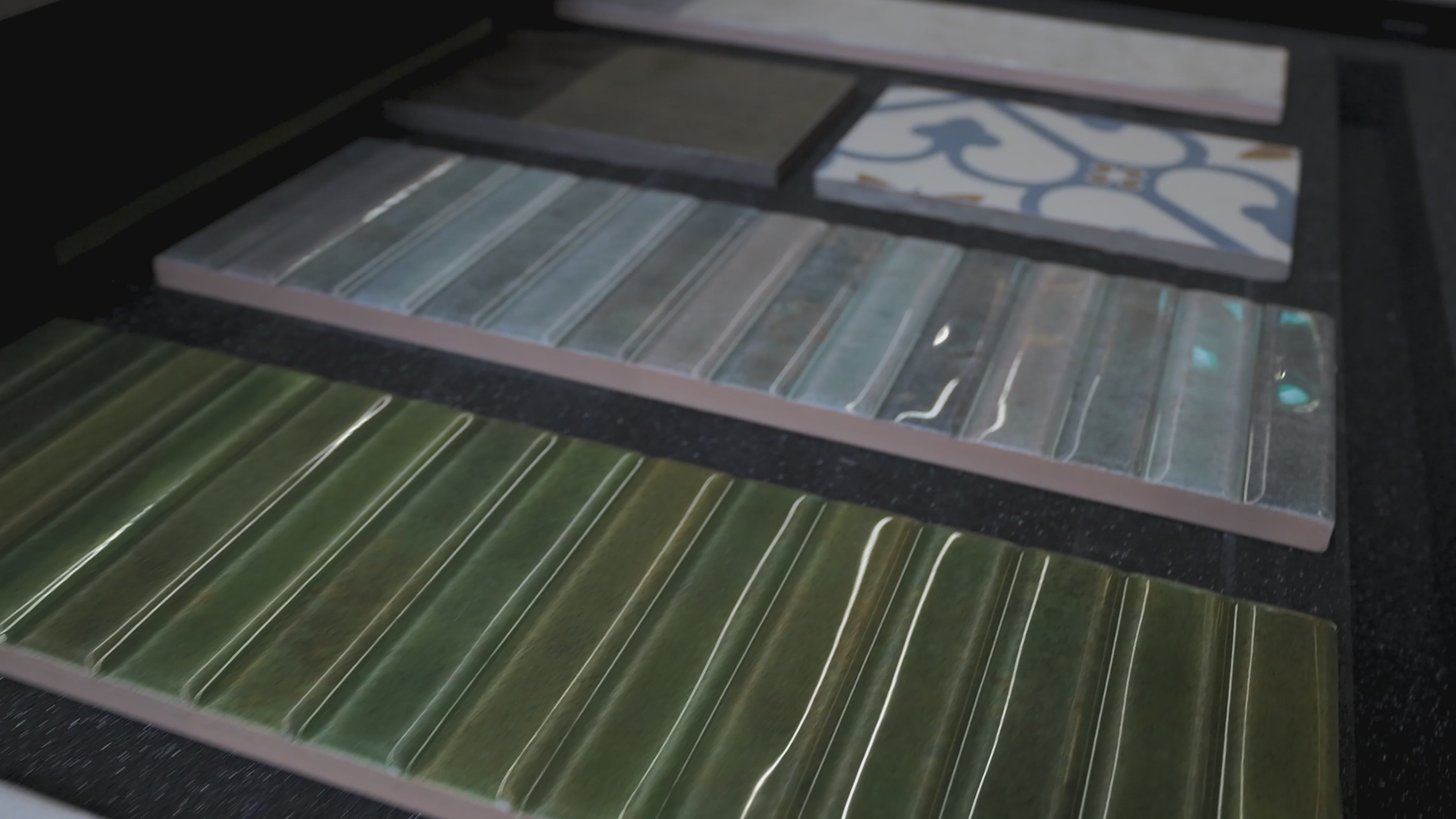 Load video: Tile samples in a box showing the finish and texture.