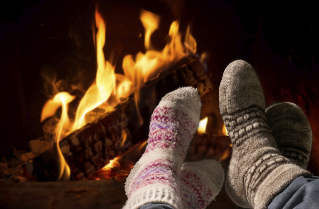 Feet in wool socks warming at the fireplace