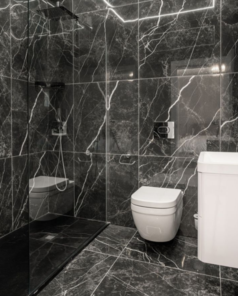 dark marble effect tiles on floor and wall in bathroom