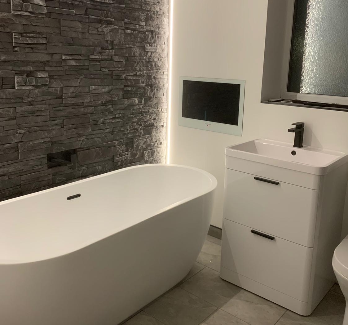 Modern bathroom with grey slate tiles and LED lights built into wall