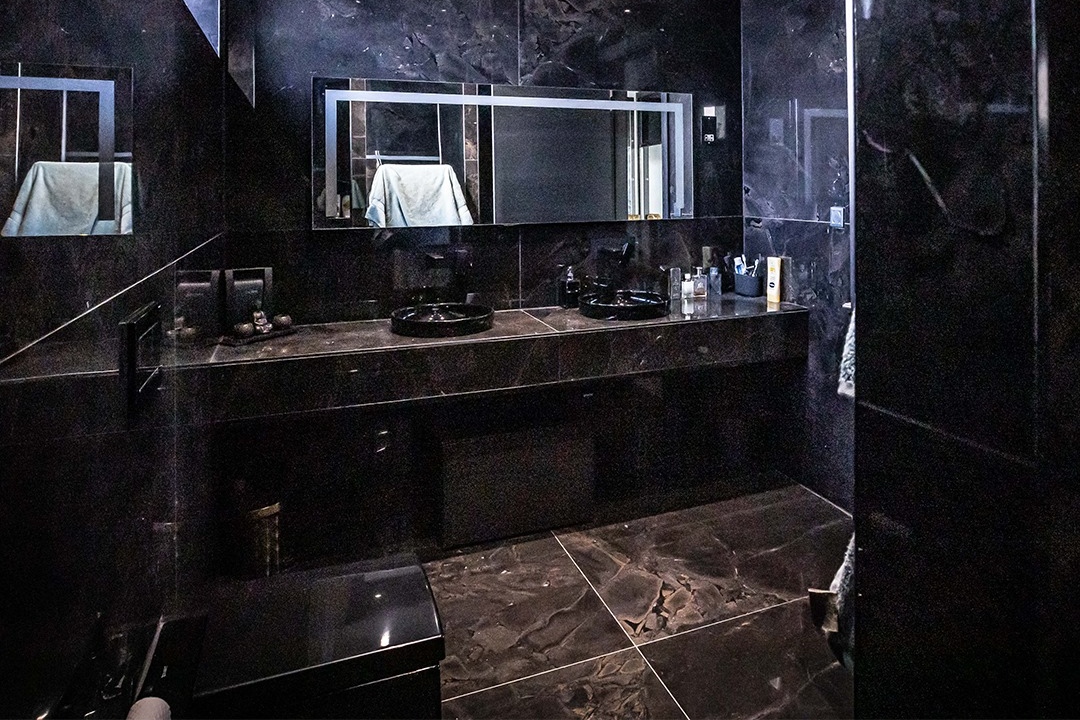 Luxurious bathroom with matching black floor and wall tiles