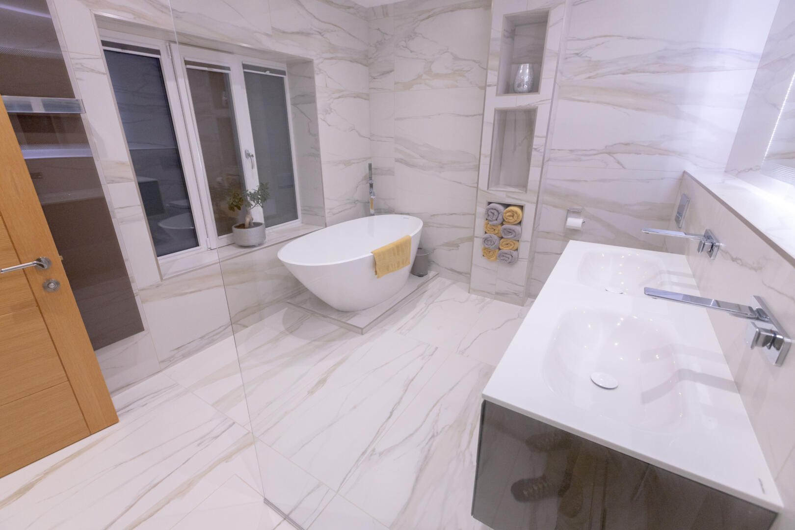 Modern spa-inspired bathroom with free-standing bath and white tiles