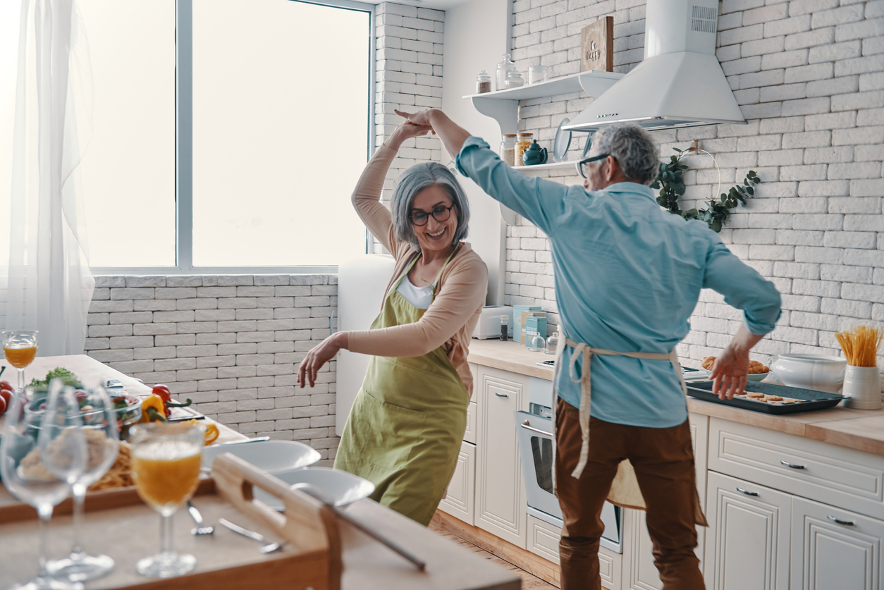 Couple dancing in a small kitchen while cooking